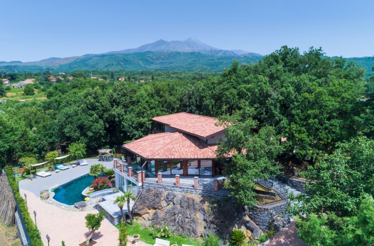 Drone view: the house, the forest inside the property and Etna volcano on the background. The sea view is on the back