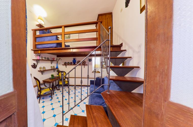The wooden staircase takes you to a loft that becomes a bedroom
