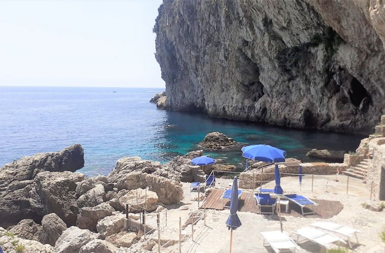 The private beach of the residence, on the right the sea cave of Isolabella