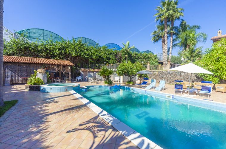 The pool and on the background the patio with BBQ area