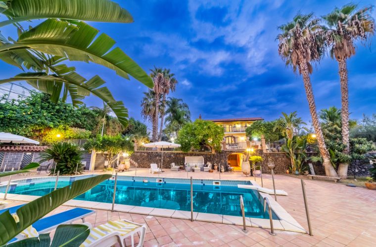 Mamma Nella is built using the renowned local lava stone which together with the tropical plants, the lawn and the Sicilian ceramics elegantly harmonize this important property.