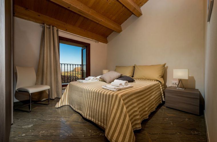 The first bedroom has a double bed and a balcony facing the pool with sea- and countryside -view.