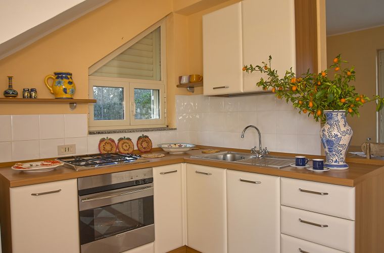 A door from the dining area leads to the kitchen which has been fitted with various floor and wall storage units, a marble work top, an oven and hob, fridge/freezer, a double sink unit, extractor fan, microwave and a kettle.